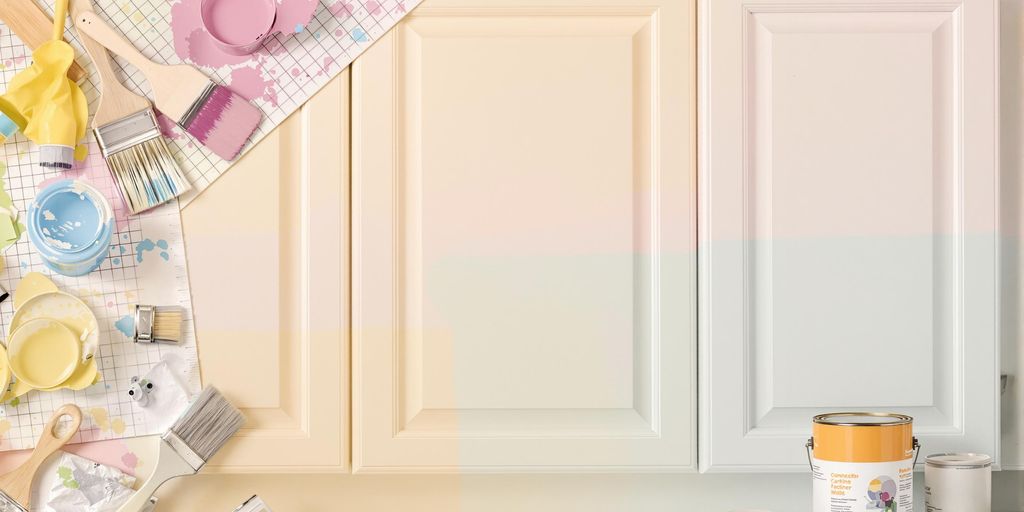 Colorful kitchen cabinet with paint supplies around it.